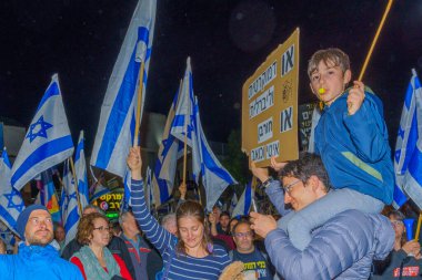 Hayfa, İsrail - 25 Mart 2023: Çeşitli tabela ve bayraklı protestocular, İsrail 'in Hayfa kentinde anti-demokratik olduğunu iddia eden yeni hükümetin planlarına karşı düzenlenen gösteriye katıldılar.