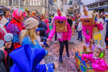 Lucerne, İsviçre - 21 Şubat 2023: Kostüm giymiş bir grup katılımcı ve kalabalık, İsviçre 'nin Lucerne kentinde düzenlenen Fasnacht Karnavalı' nın çocuk geçit töreninin bir parçası.