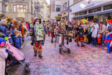 Lucerne, İsviçre - 21 Şubat 2023: Kostüm giymiş bir grup katılımcı ve kalabalık, İsviçre 'nin Lucerne kentinde düzenlenen Fasnacht Karnavalı' nın çocuk geçit töreninin bir parçası.