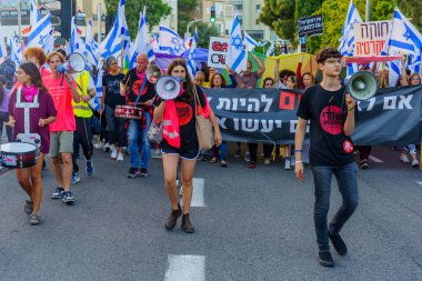 Hayfa, İsrail - 22 Nisan 2023: Hayfa, İsrail 'de antidemokratik olduğunu iddia eden hükümetin planlarına karşı çeşitli pankartlar, pankartlar ve bayraklarla protesto yürüyüşü