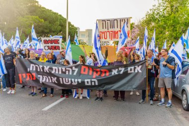 Hayfa, İsrail - 22 Nisan 2023: Hayfa, İsrail 'de antidemokratik olduğunu iddia eden hükümetin planlarına karşı çeşitli pankartlar, pankartlar ve bayraklarla protesto yürüyüşü