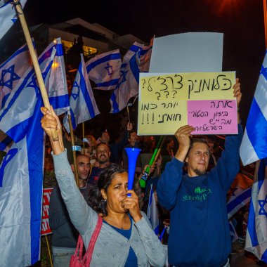 Hayfa, İsrail - 22 Nisan 2023: Çeşitli tabela ve bayraklı protestocular, İsrail 'in Hayfa kentinde anti-demokratik olduğunu iddia eden yeni hükümetin planlarına karşı düzenlenen gösteriye katıldılar.