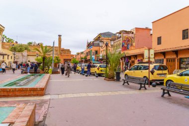 Marakeş, Fas - 05 Nisan 2023: Medine caddesi, Marakeş, Fas 'ta taksi arabaları, yerli halk ve ziyaretçilerle dolu.