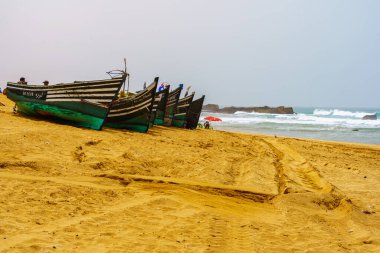 Oualidia, Fas - 08 Nisan 2023: Yerli halkla birlikte, Fas 'ın Atlantik kıyısındaki Oualidia tatil beldesinde ahşap botların görüntüsü