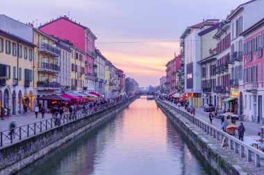 Milan, İtalya - 02 Mart 2022: Naviglio Grande kanalının Navigli, Milan, Lombardy, Kuzey İtalya 'da yerel halk ve ziyaretçilerle gün batımı manzarası