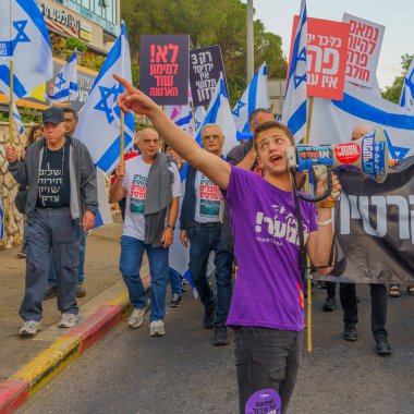 Hayfa, İsrail - 20 Mayıs 2023: İnsanlar bayraklar ve çeşitli işaretlerle yürüyor. Hayfa, İsrail 'de hükümet karşıtı gösterilerin 20. haftası