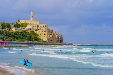 Tel Aviv, İsrail - 21 Mayıs 2023: Sörfçülerle, diğerleriyle ve eski Jaffa ile sahnenin manzarası. Tel-Aviv, İsrail