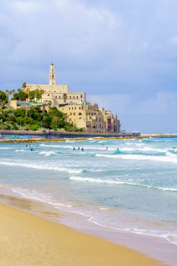 Tel Aviv, İsrail - 21 Mayıs 2023: Sörfçülerle, diğerleriyle ve eski Jaffa ile sahnenin manzarası. Tel-Aviv, İsrail