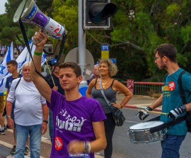 Hayfa, İsrail - 27 Mayıs 2023: İnsanlar bayraklar ve çeşitli işaretlerle yürüyor. Hayfa, İsrail 'de 21. hükümet karşıtı protesto haftası