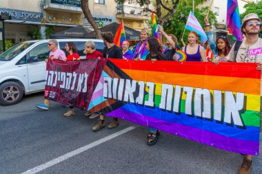 Hayfa, İsrail - 15 Haziran 2023: İsrail 'in Hayfa kentindeki her yıl düzenlenen LGBTQ + toplumunun Onur Yürüyüşü' nde çeşitli protesto işaretleriyle yürüyüş yapan katılımcıların görüntüsü