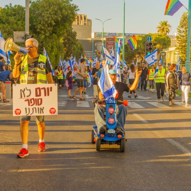 Hayfa, İsrail - 24 Haziran 2023: İnsanlar bayraklar ve çeşitli işaretlerle yürüyor. Hayfa, İsrail 'de 25 haftalık hükümet karşıtı protesto