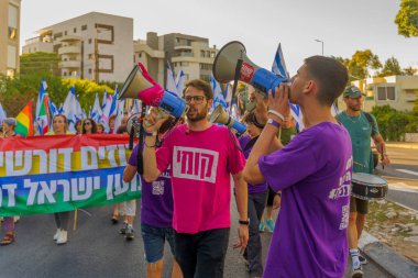Hayfa, İsrail - 24 Haziran 2023: İnsanlar bayraklar ve çeşitli işaretlerle yürüyor. Hayfa, İsrail 'de 25 haftalık hükümet karşıtı protesto
