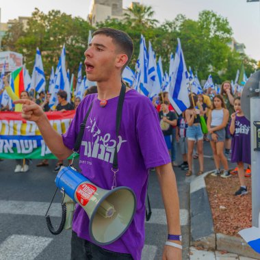 Hayfa, İsrail - 24 Haziran 2023: İnsanlar bayraklar ve çeşitli işaretlerle yürüyor. Hayfa, İsrail 'de 25 haftalık hükümet karşıtı protesto
