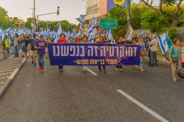 Hayfa, İsrail - 24 Haziran 2023: İnsanlar bayraklar ve çeşitli işaretlerle yürüyor. Hayfa, İsrail 'de 25 haftalık hükümet karşıtı protesto