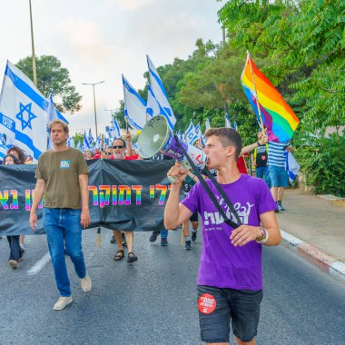 Hayfa, İsrail - 01 Temmuz 2023: İnsanlar bayraklar ve çeşitli işaretlerle yürüyor. Hayfa, İsrail 'de 26 haftalık hükümet karşıtı protesto