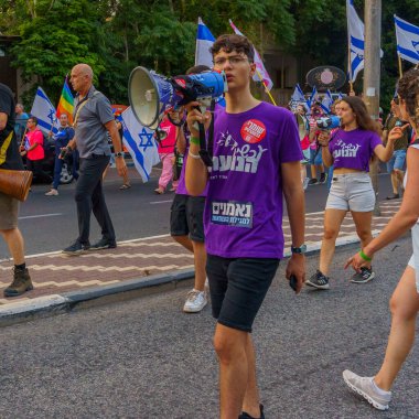 Hayfa, İsrail - 01 Temmuz 2023: İnsanlar bayraklar ve çeşitli işaretlerle yürüyor. Hayfa, İsrail 'de 26 haftalık hükümet karşıtı protesto