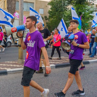 Hayfa, İsrail - 01 Temmuz 2023: İnsanlar bayraklar ve çeşitli işaretlerle yürüyor. Hayfa, İsrail 'de 26 haftalık hükümet karşıtı protesto