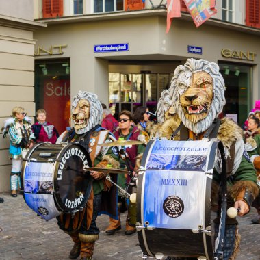 Lucerne, İsviçre - 20 Şubat 2023: Kostüm giymiş müzisyenler ve Fasnacht Karnavalı 'nın bir parçası olan kalabalık, İsviçre' nin başkenti Lucerne 'de yürüyüşe geçti.
