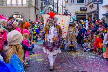 Lucerne, İsviçre - 21 Şubat 2023: Kostüm giymiş bir grup katılımcı ve kalabalık, İsviçre 'nin Lucerne kentinde düzenlenen Fasnacht Karnavalı' nın çocuk geçit töreninin bir parçası.
