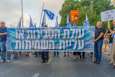 Hayfa, İsrail - 8 Temmuz 2023: İnsanlar bayraklar ve çeşitli işaretlerle yürüyor. Hayfa, İsrail 'de 27 haftalık hükümet karşıtı protesto