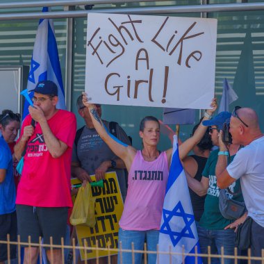 Hayfa, İsrail - 18 Temmuz 2023: İnsanlar tren istasyonunda bayraklar ve çeşitli tabelalarla protesto ediyorlar. Hayfa, İsrail 'de tartışmalı yargı revizyonuna karşı bozulma günü