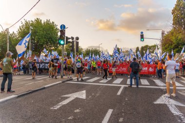 Hayfa, İsrail - 29 Temmuz 2023: İnsanlar slogan altında çeşitli işaretlerle yürüyorlar: Asla teslim olmayacağız. 30 haftalık tartışmalı adli elden geçirme protestosunun bir parçası. Hayfa, İsrail