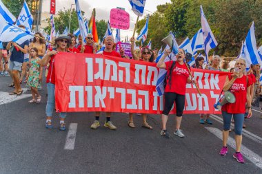 Hayfa, İsrail - 29 Temmuz 2023: İnsanlar slogan altında çeşitli işaretlerle yürüyorlar: Asla teslim olmayacağız. 30 haftalık tartışmalı adli elden geçirme protestosunun bir parçası. Hayfa, İsrail