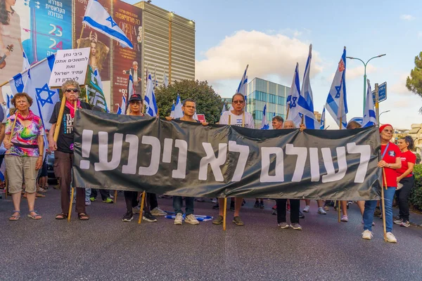 stock image Haifa, Israel - July 29, 2023: People march with various signs under the slogan: we shall never surrender. Part of week 30 of protest against controversial judicial overhaul. Haifa, Israel