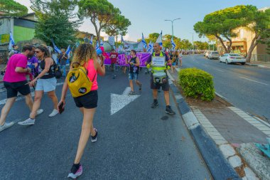 Hayfa, İsrail - 05 Ağustos 2023: İnsanlar çeşitli bayrak ve işaretlerle yürüyor, slogan: Daha iyi bir gelecekten vazgeçmeyeceğiz. Tartışmalı adli elden geçirme karşıtı 31. hafta protestosu. Hayfa, İsrail