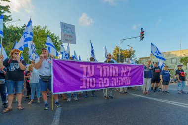 Hayfa, İsrail - 05 Ağustos 2023: İnsanlar çeşitli bayrak ve işaretlerle yürüyor, slogan: Daha iyi bir gelecekten vazgeçmeyeceğiz. Tartışmalı adli elden geçirme karşıtı 31. hafta protestosu. Hayfa, İsrail