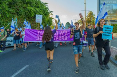 Hayfa, İsrail - 05 Ağustos 2023: İnsanlar çeşitli bayrak ve işaretlerle yürüyor, slogan: Daha iyi bir gelecekten vazgeçmeyeceğiz. Tartışmalı adli elden geçirme karşıtı 31. hafta protestosu. Hayfa, İsrail