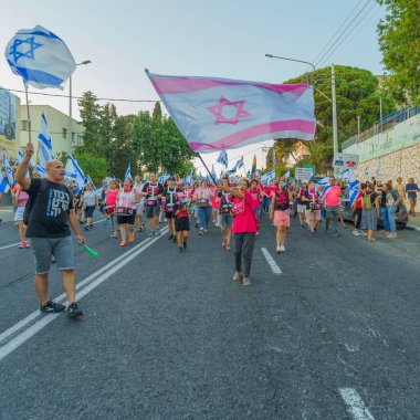 Hayfa, İsrail - 05 Ağustos 2023: İnsanlar çeşitli bayrak ve işaretlerle yürüyor, slogan: Daha iyi bir gelecekten vazgeçmeyeceğiz. Tartışmalı adli elden geçirme karşıtı 31. hafta protestosu. Hayfa, İsrail