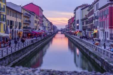 Milan, İtalya - 02 Mart 2022: Naviglio Grande kanalının Navigli, Milan, Lombardy, Kuzey İtalya 'da yerel halk ve ziyaretçilerle gün batımı manzarası