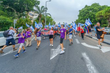 Hayfa, İsrail - 12 Ağustos 2023: İnsanlar çeşitli bayrak ve işaretlerle yürüyor. Tartışmalı adli elden geçirme karşıtı 32. hafta protestosu. Hayfa, İsrail