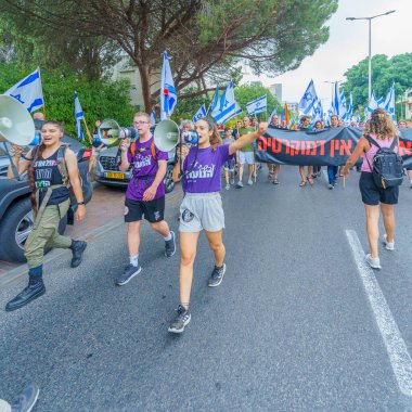 Hayfa, İsrail - 12 Ağustos 2023: İnsanlar çeşitli bayrak ve işaretlerle yürüyor. Tartışmalı adli elden geçirme karşıtı 32. hafta protestosu. Hayfa, İsrail