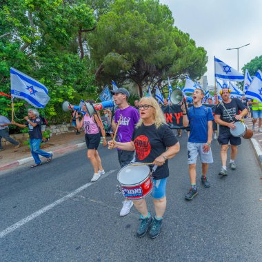 Hayfa, İsrail - 12 Ağustos 2023: İnsanlar çeşitli bayrak ve işaretlerle yürüyor. Tartışmalı adli elden geçirme karşıtı 32. hafta protestosu. Hayfa, İsrail