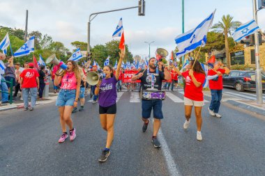 Hayfa, İsrail - 19 Ağustos 2023: İnsanlar çeşitli bayrak ve işaretlerle yürüyor. 33 haftalık tartışmalı adli elden geçirme protestosu. Hayfa, İsrail