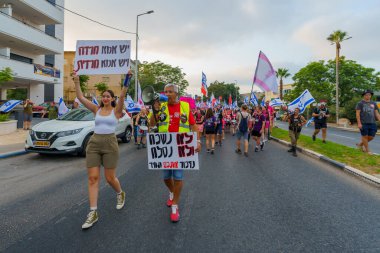 Hayfa, İsrail - 19 Ağustos 2023: İnsanlar çeşitli bayrak ve işaretlerle yürüyor. 33 haftalık tartışmalı adli elden geçirme protestosu. Hayfa, İsrail
