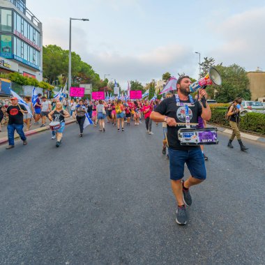 Hayfa, İsrail - 19 Ağustos 2023: İnsanlar çeşitli bayrak ve işaretlerle yürüyor. 33 haftalık tartışmalı adli elden geçirme protestosu. Hayfa, İsrail