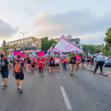 Hayfa, İsrail - 19 Ağustos 2023: İnsanlar çeşitli bayrak ve işaretlerle yürüyor. 33 haftalık tartışmalı adli elden geçirme protestosu. Hayfa, İsrail