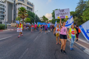 Hayfa, İsrail - 26 Ağustos 2023: İnsanlar hava kuvvetleri pilotları tarafından yönetilen çeşitli işaret ve bayraklarla yürüyor. 34. hafta tartışmalı adli elden geçirme protestosu. Hayfa, İsrail