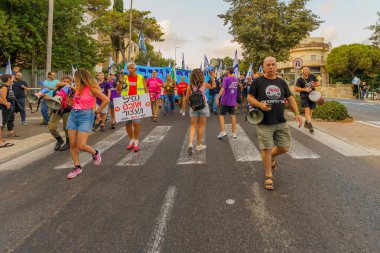 Hayfa, İsrail - 26 Ağustos 2023: İnsanlar hava kuvvetleri pilotları tarafından yönetilen çeşitli işaret ve bayraklarla yürüyor. 34. hafta tartışmalı adli elden geçirme protestosu. Hayfa, İsrail