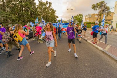 Hayfa, İsrail - 26 Ağustos 2023: İnsanlar hava kuvvetleri pilotları tarafından yönetilen çeşitli işaret ve bayraklarla yürüyor. 34. hafta tartışmalı adli elden geçirme protestosu. Hayfa, İsrail