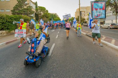 Hayfa, İsrail - 26 Ağustos 2023: İnsanlar hava kuvvetleri pilotları tarafından yönetilen çeşitli işaret ve bayraklarla yürüyor. 34. hafta tartışmalı adli elden geçirme protestosu. Hayfa, İsrail