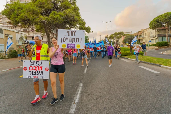 stock image Haifa, Israel - August 26, 2023: People march with various signs and flags, led by air force pilots. Week 34 of protest against controversial judicial overhaul. Haifa, Israel