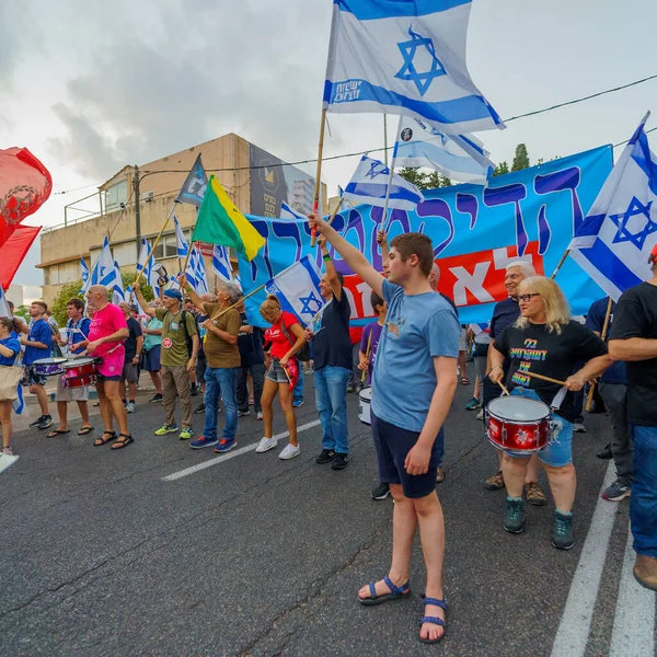 stock image Haifa, Israel - August 26, 2023: People march with various signs and flags, led by air force pilots. Week 34 of protest against controversial judicial overhaul. Haifa, Israel