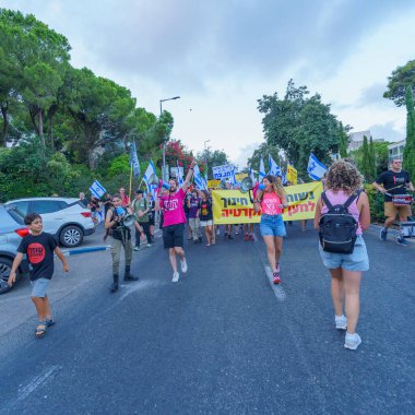 Hayfa, İsrail - 02 Eylül 2023: İnsanlar eğitimcilerin önderliğinde çeşitli tabela ve bayraklarla yürüyor. 35. hafta tartışmalı adli elden geçirme protestosu. Hayfa, İsrail