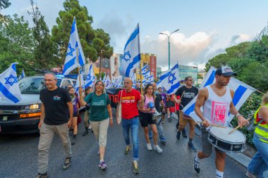 Hayfa, İsrail - 09 Eylül 2023: İnsanlar çeşitli tabela ve bayraklarla yürüyor. 36 haftalık tartışmalı adli elden geçirme protestosu. Hayfa, İsrail
