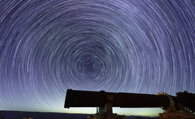 Makhtesh (krater) Ramon, Negev Çölü, Güney İsrail 'deki eski bir taş ocağının üzerindeki yıldız izleri ve perseid meteorların görüntüsü.