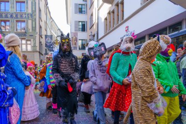 Lucerne, İsviçre - 21 Şubat 2023: Kostüm giymiş bir grup katılımcı ve kalabalık, İsviçre 'nin Lucerne kentinde düzenlenen Fasnacht Karnavalı' nın çocuk geçit töreninin bir parçası.